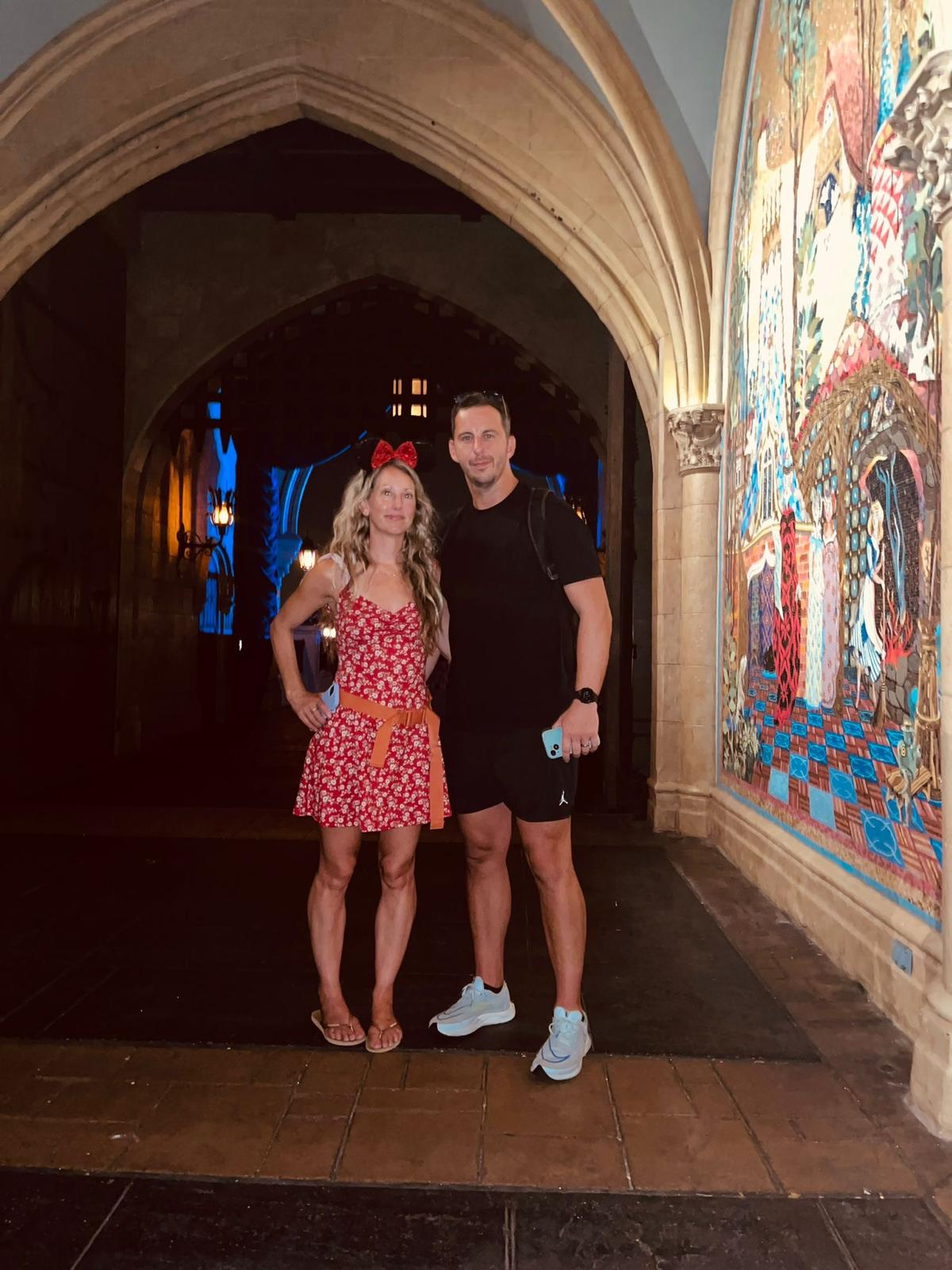 Me and my wife under the castle archway at Magic Kingdom